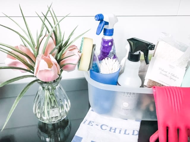 a plastic tote with cleaning supplies to help prepare for overnight guests