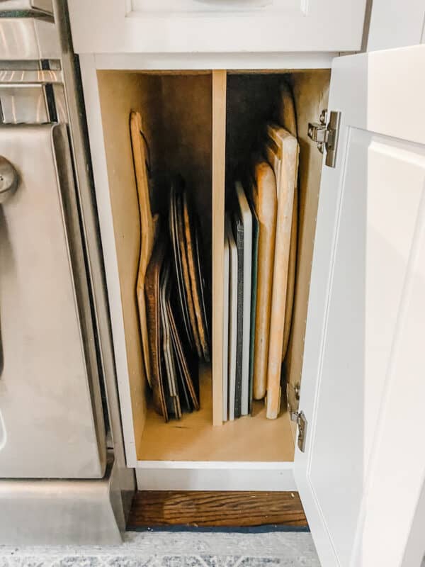 a organized kitchen cabinet with my cutting boards and baking sheets stacked