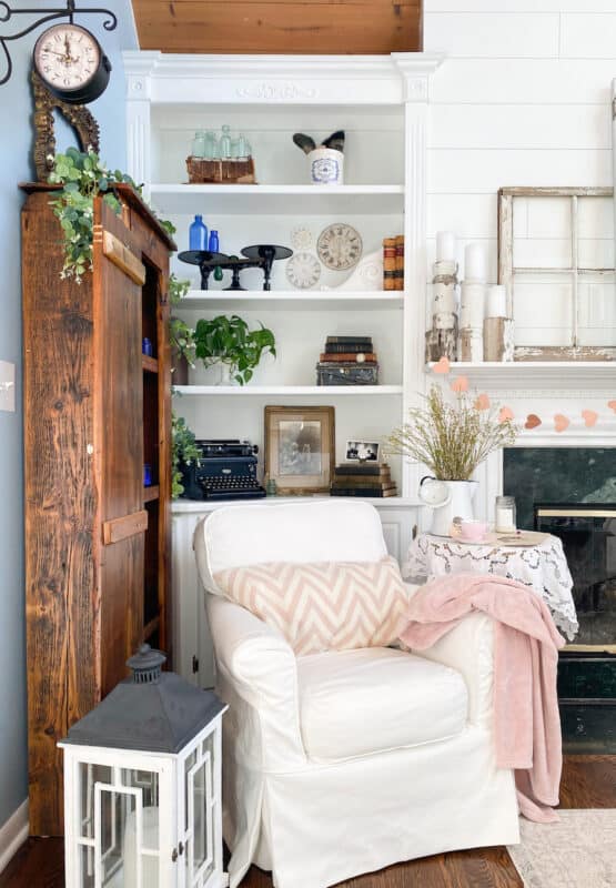 planning a fun Valentine's Day with a pretty pink pillow on a white chair and a pink throw.