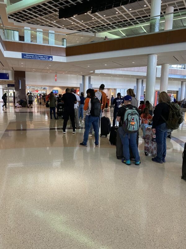 People standing in a two hour long line to rent a car