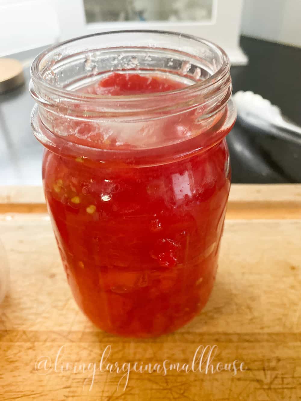blanched tomatoes cut and packed into pint jar for fresh tomato flavor all year long