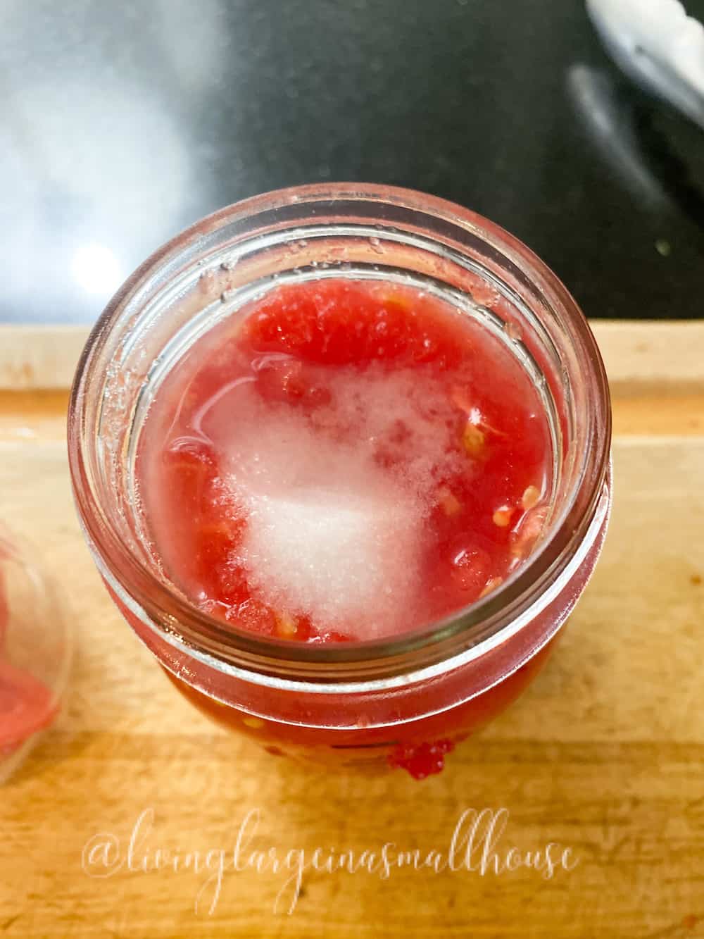 blanched tomatoes cut and packed into pint jar with salt and lemon juice for fresh tomato flavor all year long