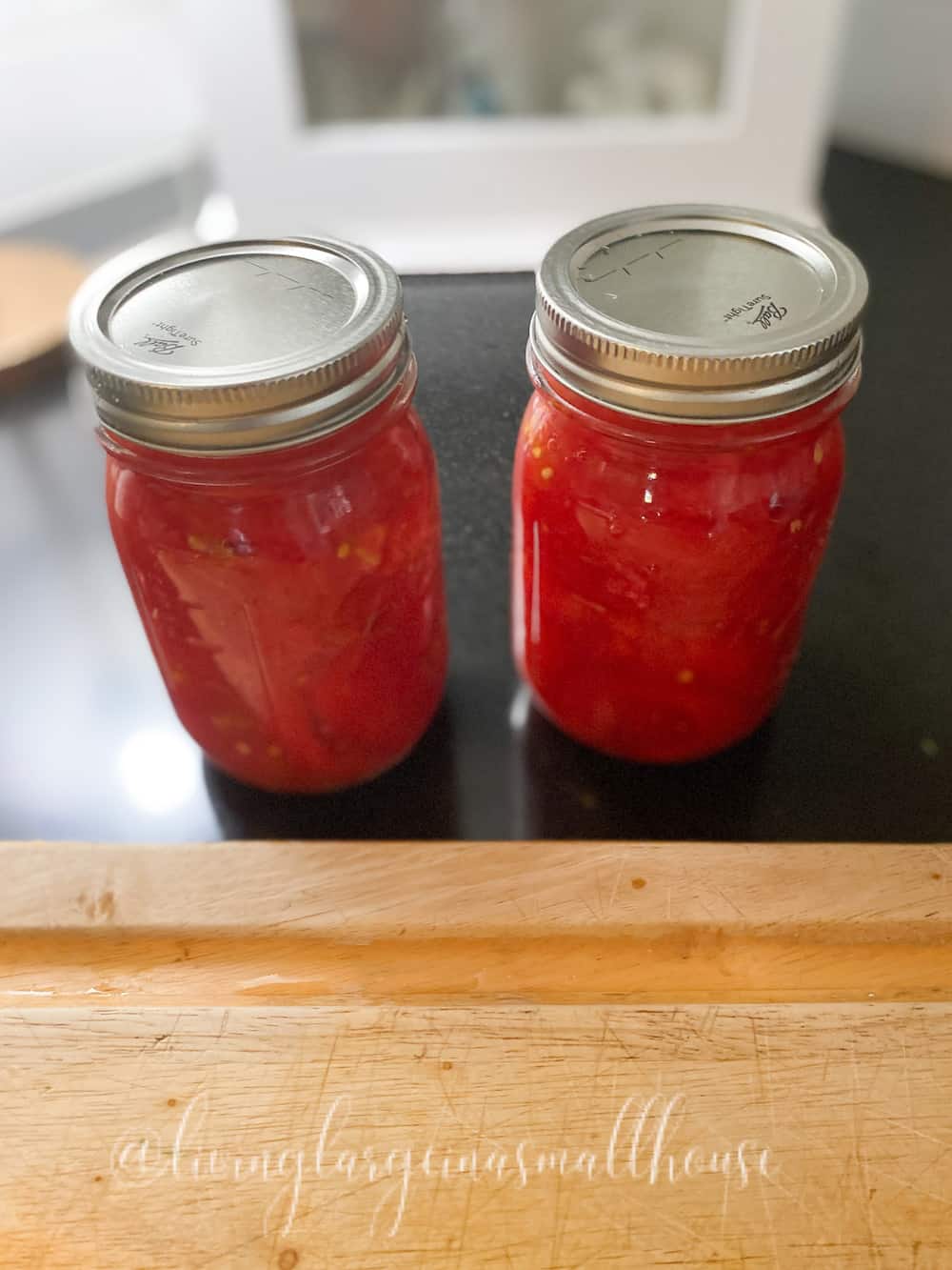 blanched tomatoes cut and packed into pint jar with lids for fresh tomato flavor all year long