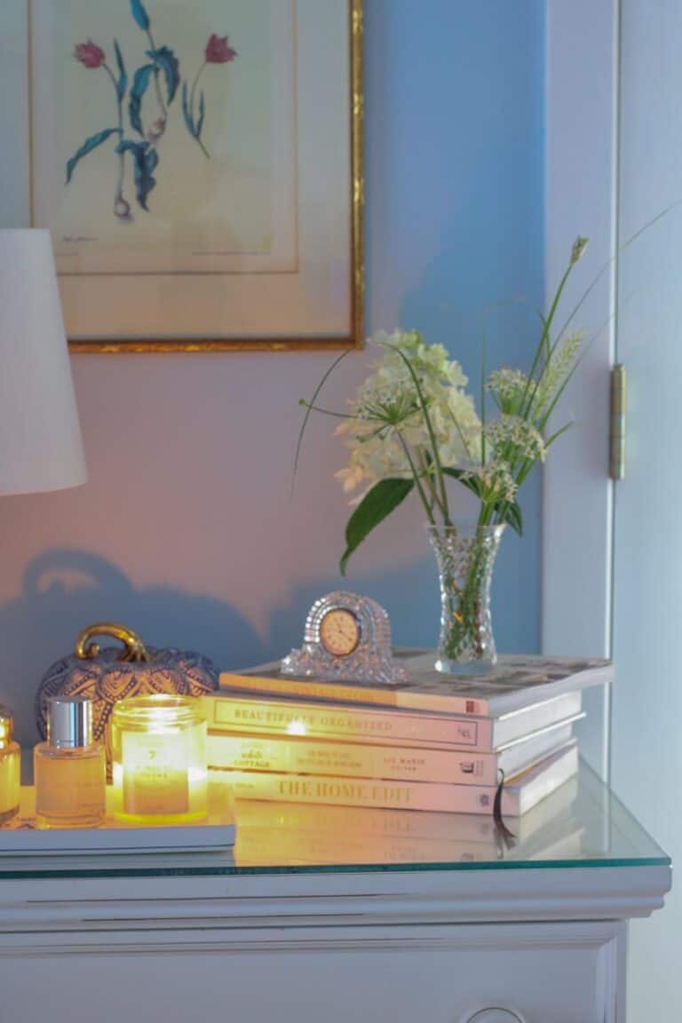 picture of my nightstand with a candle, book and flowers for my post of how to make a cozy bedroom.