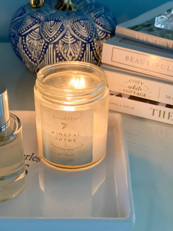 A candle next to the bed adds cozy to a bedroom