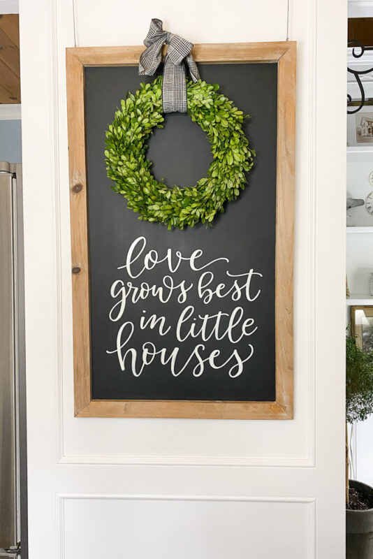 typography sign that says "love grows best in little houses"