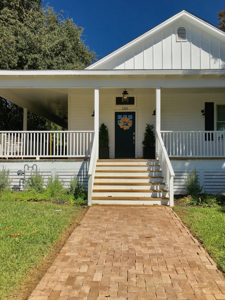 picture of my 100 year old Waco airbnb home in Waco TX. Beautiful farmstyle white home with wrap around porch