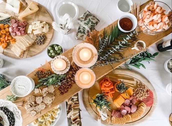 photo of a charcuterie table with cheese, crackers, nuts, olive, shrimp and more to entertain on a budget