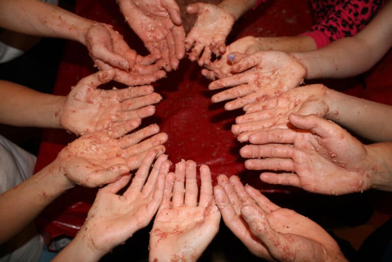 kids hands covered with potato sausage in a circle