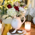 White vase with christmas flowers and a plate of s'more snack in front of tree for a quiet christmas