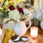White vase with christmas flowers and a plate of s'more snack in front of tree for a quiet christmas