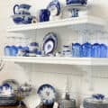 black open shelves after they have been painted white with dixie belle paint. beautiful display of flow blue china on them