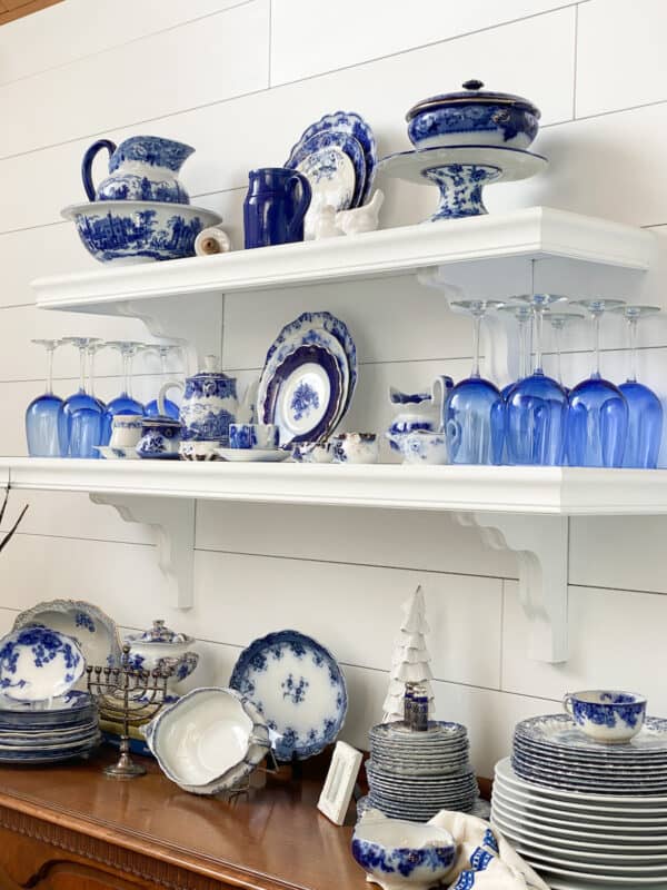 black open shelves after they have been painted white with dixie belle paint. beautiful display of flow blue china on them