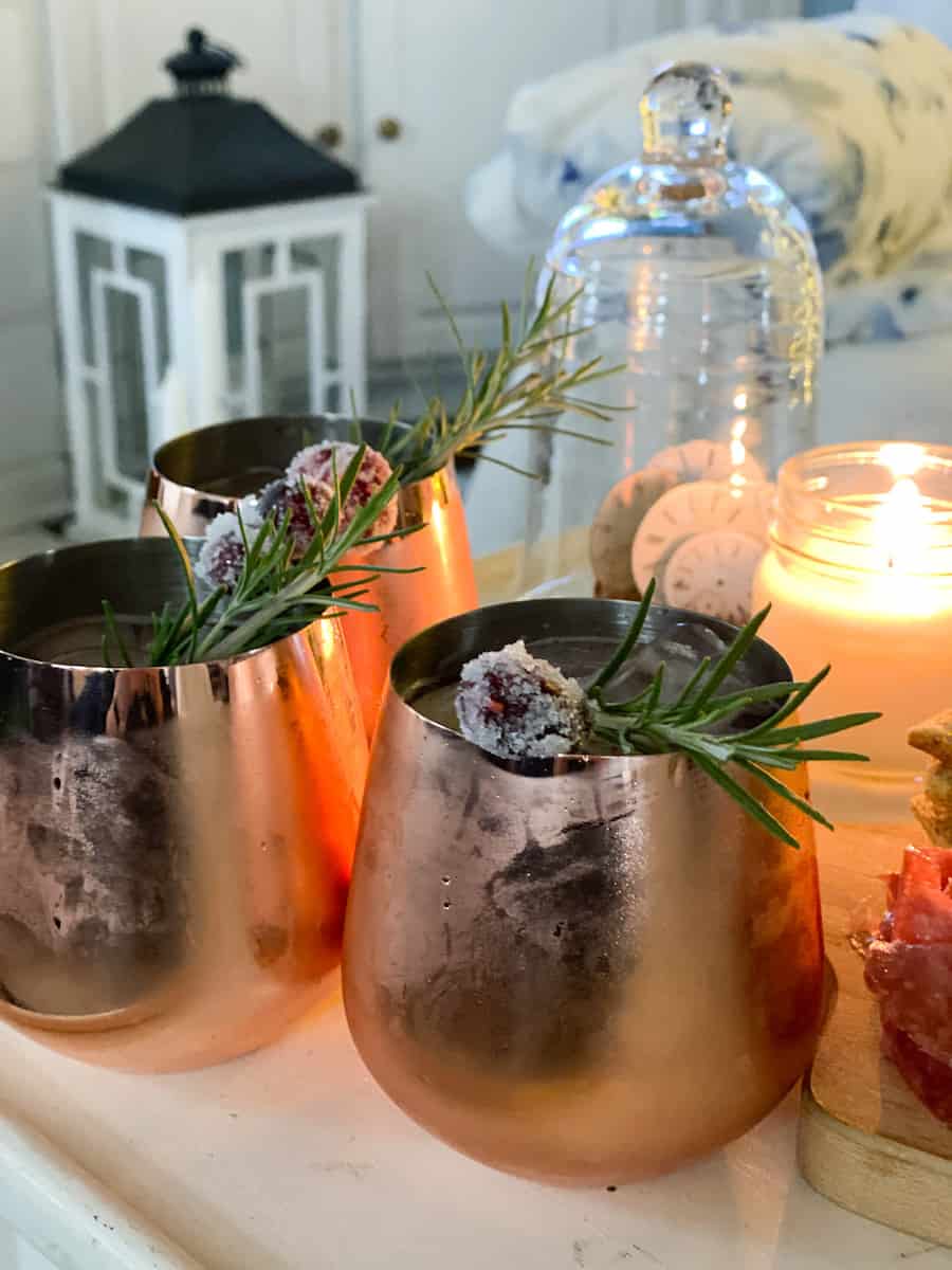 copper glasses with cranberry Moscow mules on table with candle