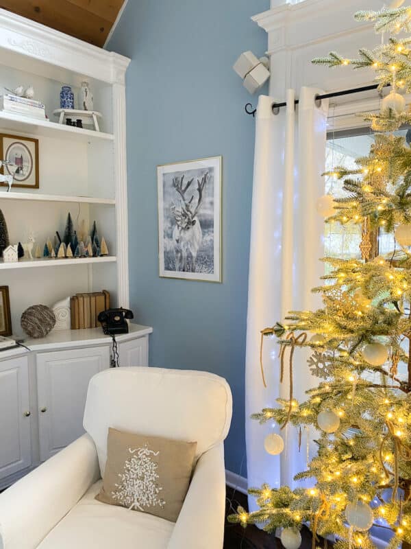 picture of reindeer from poster store on blue wall over chair and next to christmas tree