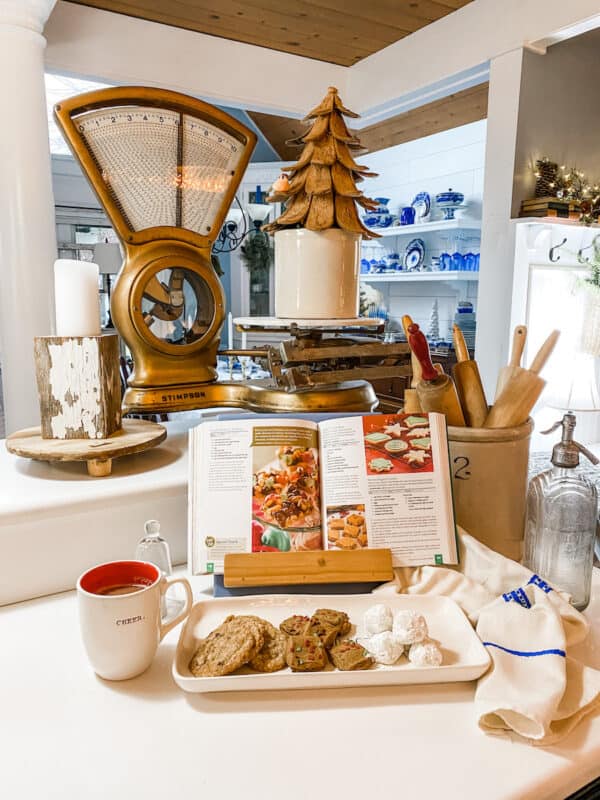Christmas Vignette in the kitchen with gold scale, crock with a tree, cookies and hot chocolate