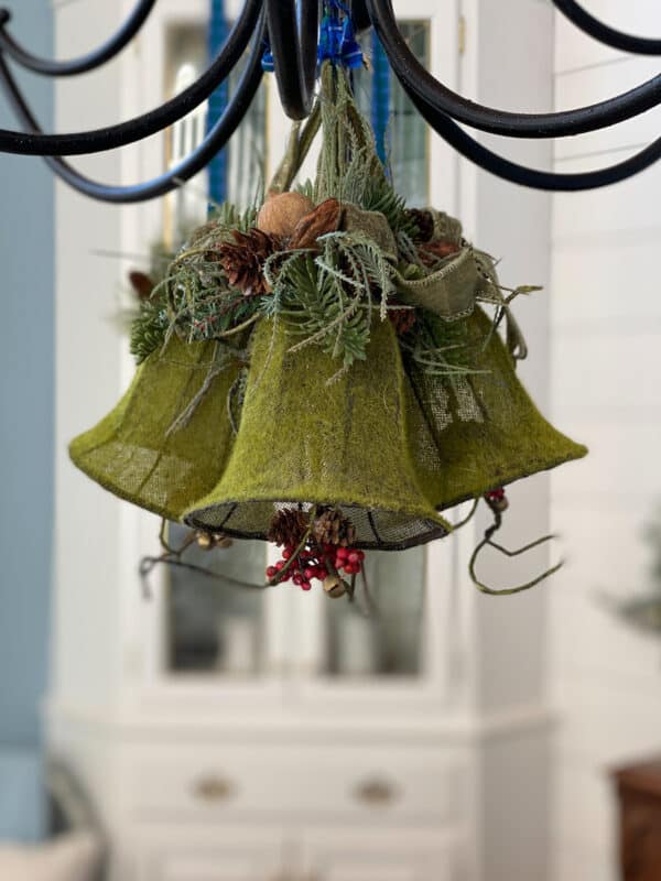 christmas decor hanging from chandeleir in the dining room