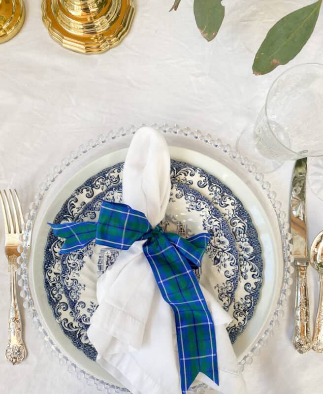 table setting with blue tableware, silver utensils and crystal glassware