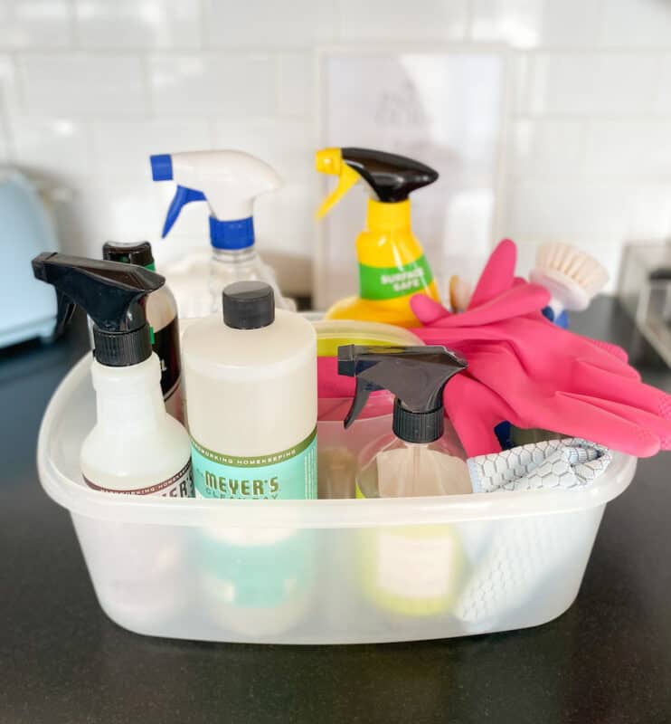 picture of plastic caddy with various cleaning supplies, gloves and rags