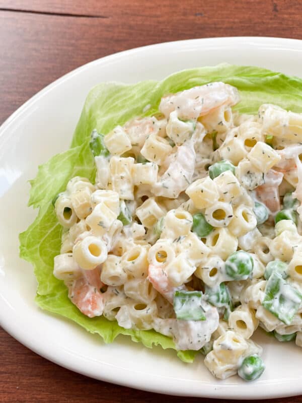 pasta and shrimp salad on top of a piece of lettuce on an oval plate. Great 4th of July Summer Salad