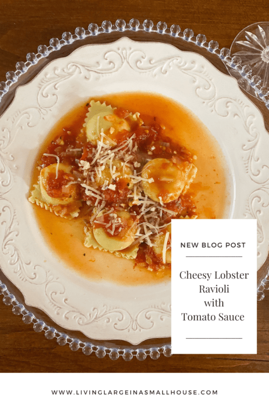 pinterest pin with overlay that reads "Cheesy Lobster Ravioli with Tomato Sauce" over picture of lobster on table