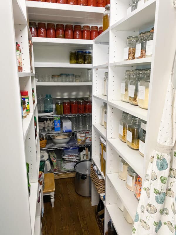 Pantry under the stairs with white laminate 8" shelves on both sides and a wire rack in the back
