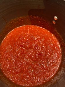 stock pot with marinara sauce cooking in it