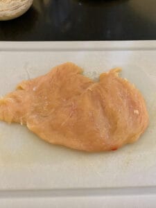 a flattened chicken breast on a cutting board