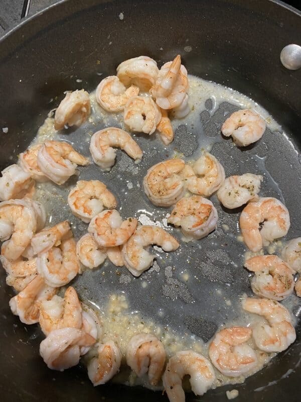 Saute pan with cooked shrimp, butter and garlic