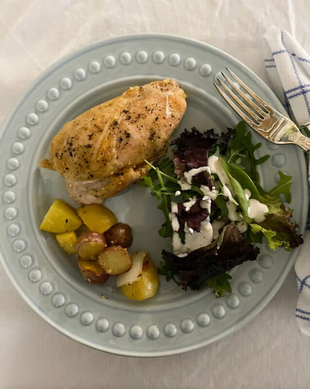 Sunday dinner with a split chicken breast, roasted potatoes and spring greens with homemade ranch dressing