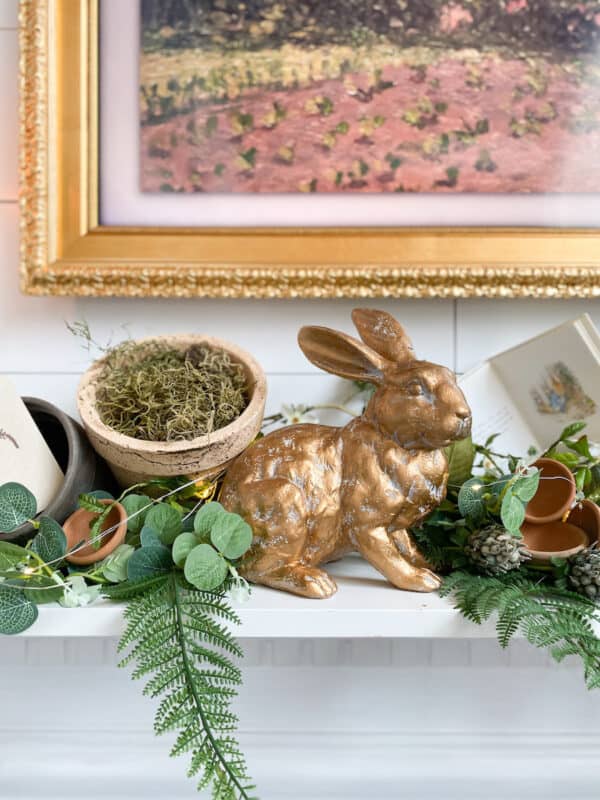 so many budget-friendly spring mantel with books, moss, bunny, terra cotta pots, and greenery