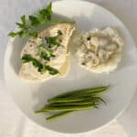 white plate with easy creamy chicken marsala, rice with additional sauce on top and steamed green beans.