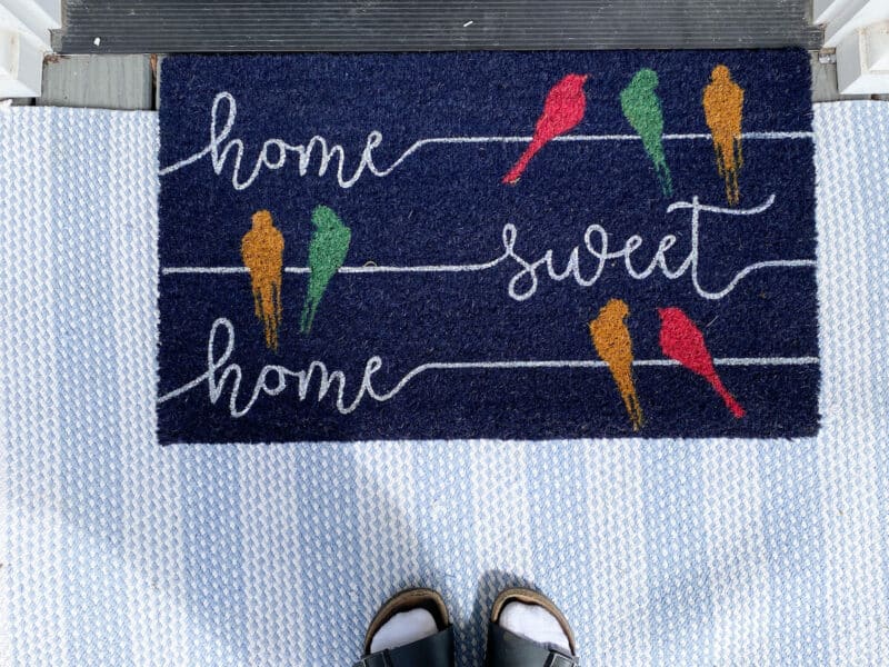 large blue and white rag rug with a door mat that says "home sweet home". Part of my spring has sprung - front porch edition.