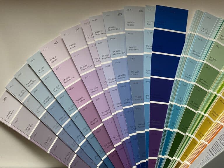 a sherwin williams paint deck fanned out with bright colors to pick the right paint color