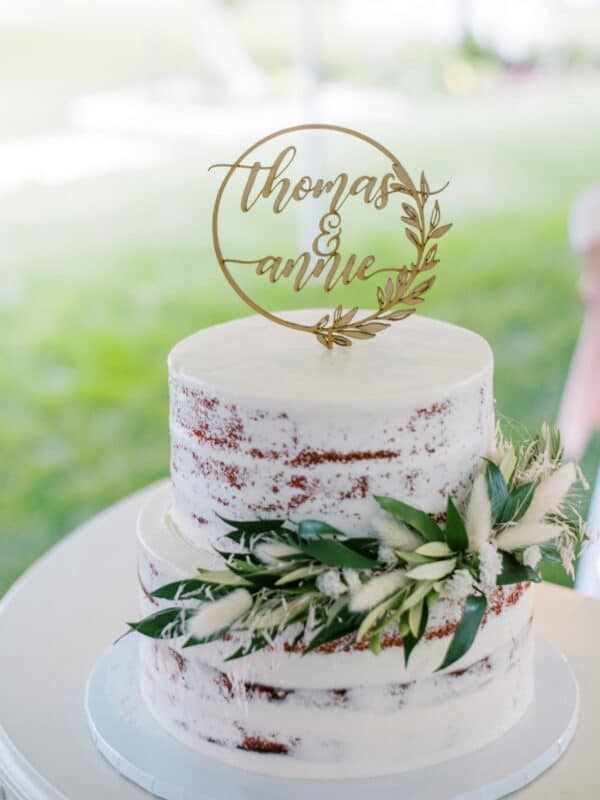a naked wedding cake with a wooden topper that says Thomas & Annie for their covid wedding