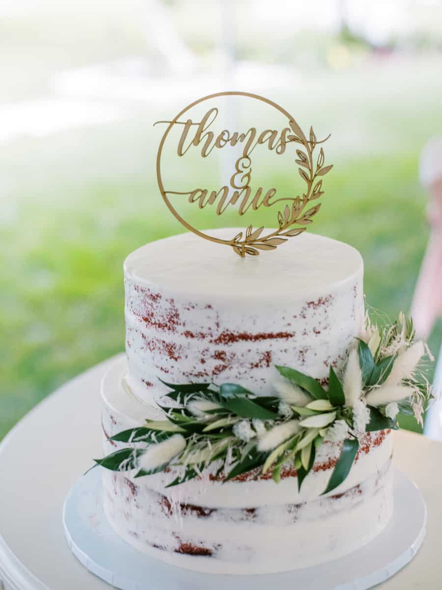 a naked wedding cake with a wooden topper that says Thomas & Annie for their covid wedding
