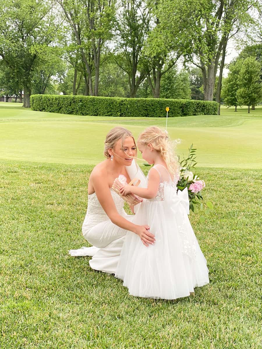 the bride squatting down to talk to the flower girl. Wish we would have hired a wedding assistant
