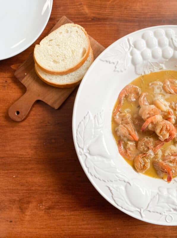 white serving bowl with cajun butter sauce and shrimp