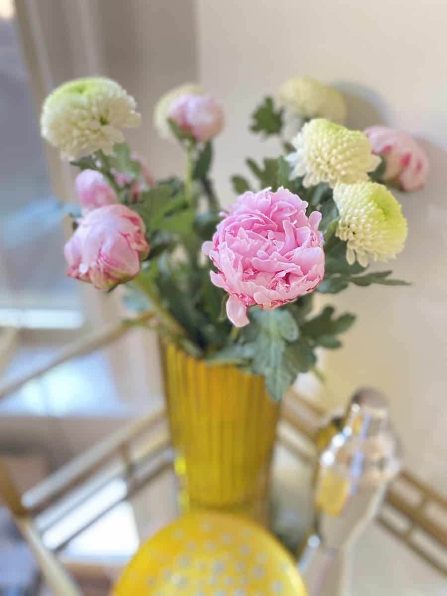 yellow vase with pink peonies and white carnations in the vase