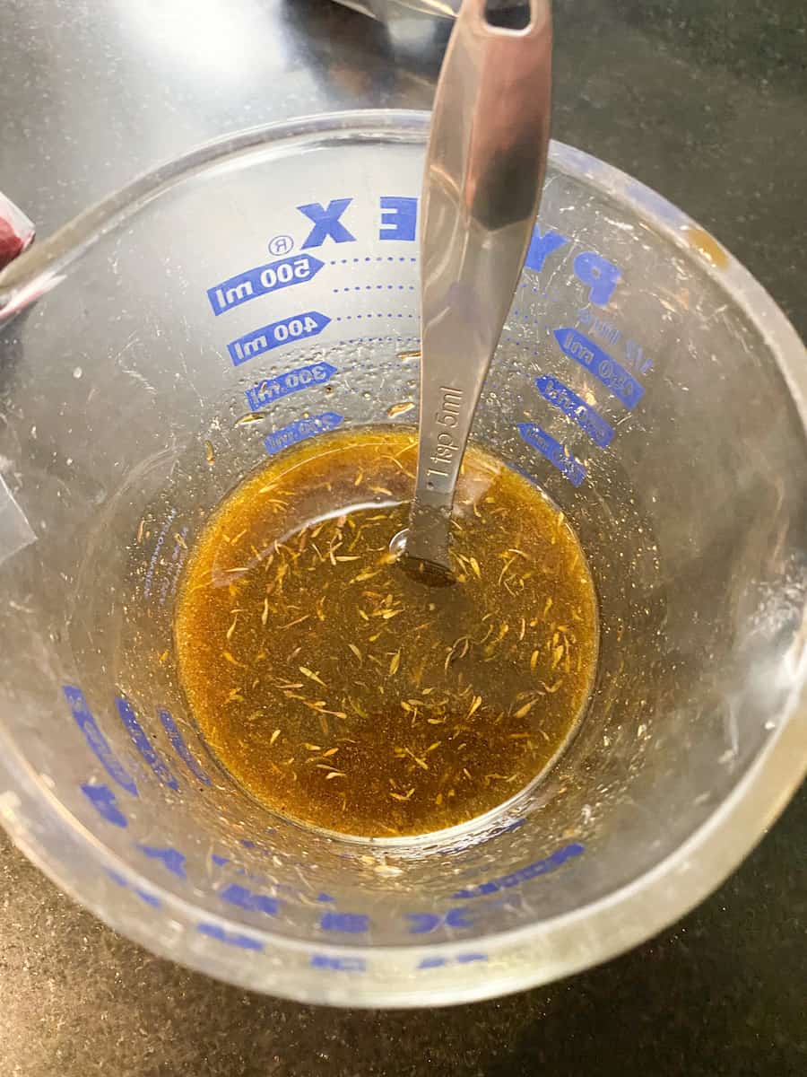 a large glass measuring cup with the ingredients for the marinade combined