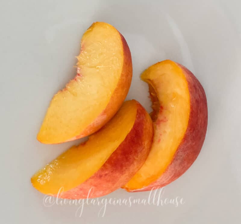 picture of three peach slices on a white plate - ready for simple peach syrup recipe