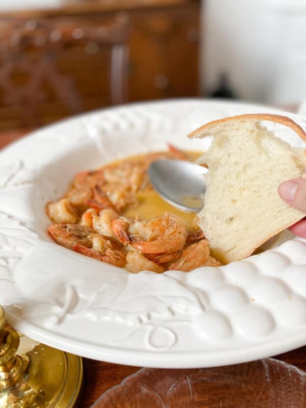 dipping bread into shrimp with cajun butter sauce