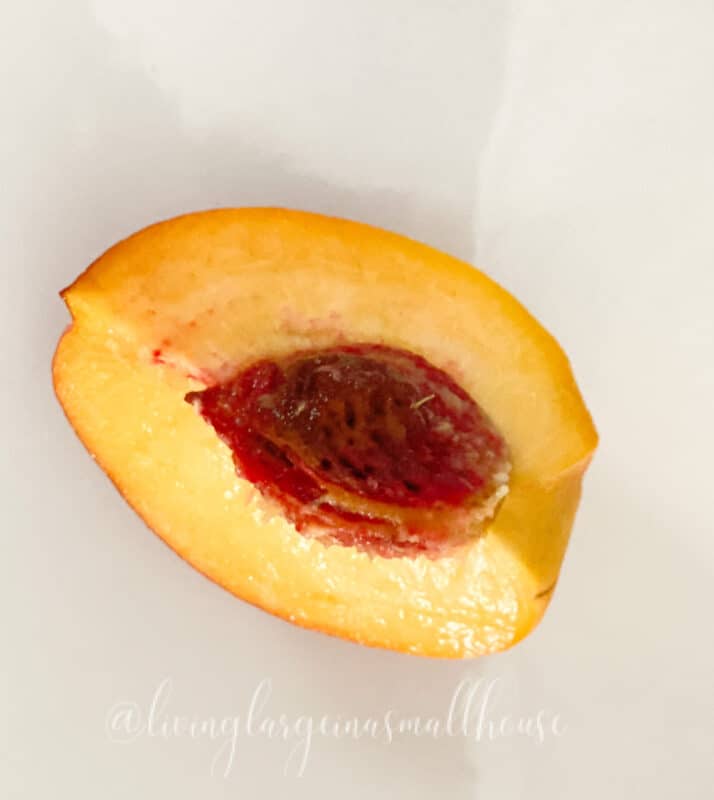 a picture of a quarter of a peach with the pit. Simple and beautiful