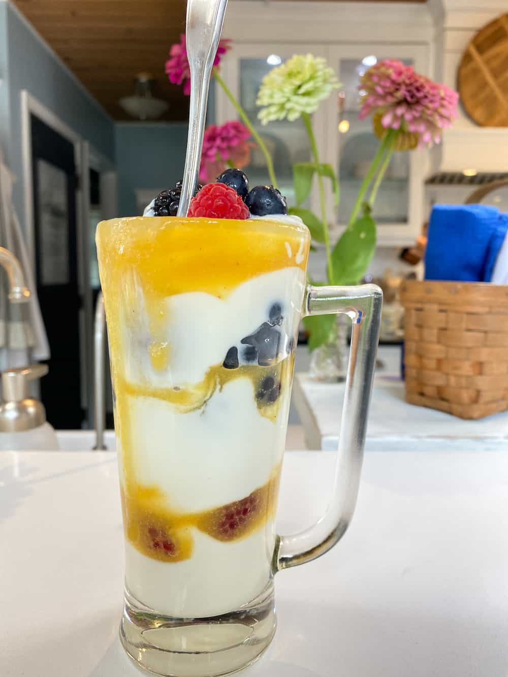 peach syrup, yogurt and fresh berries layered in a glass mug