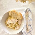 served easy homemade Alfredo sauce in a bowl with bread on the table