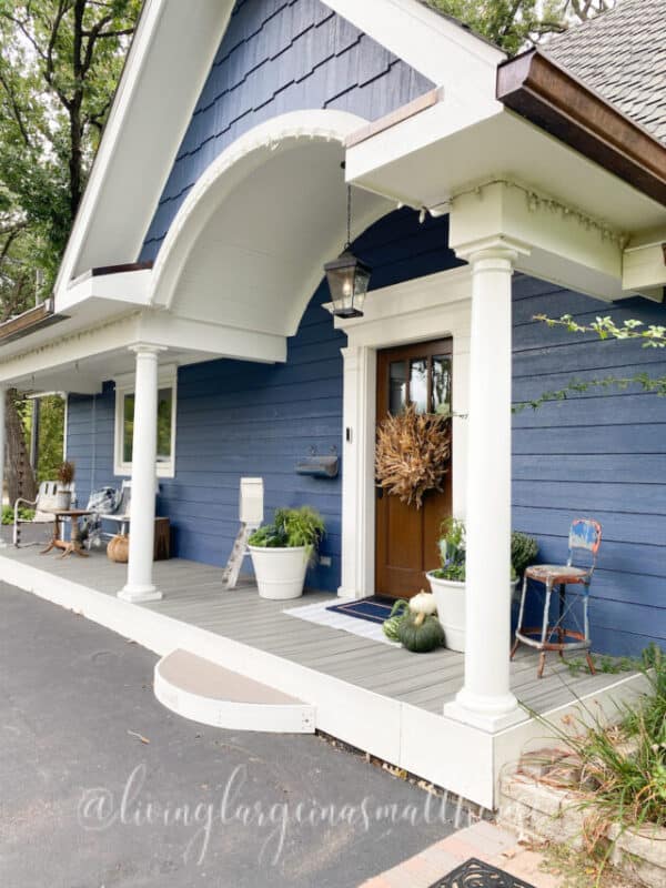 popular view of my blue sided home and our front porch dressed for fall with simple fall porch decor ideas