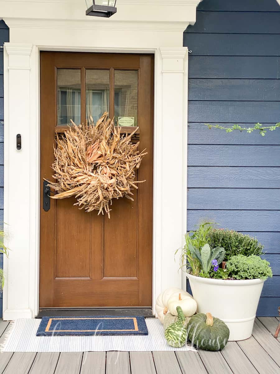 fall front door with the refreshed flower pot and pumpkins on the right