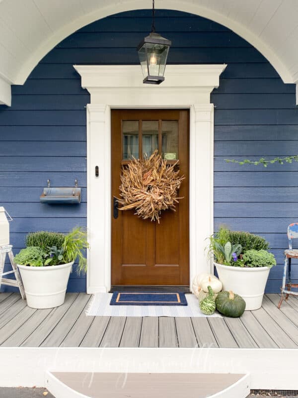 my front porch door flanked by two pots refreshed with fall flowers