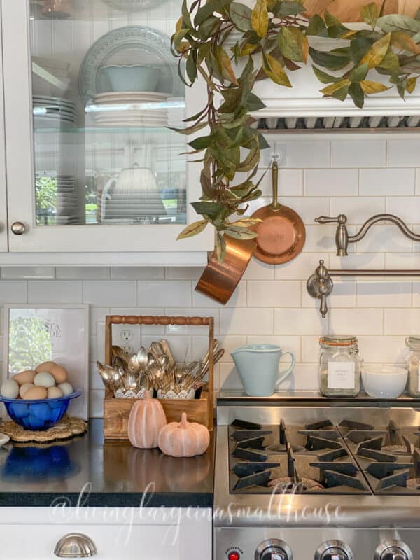 my kitchen decorated for the season of autumn with fall faux garland on the oven hood