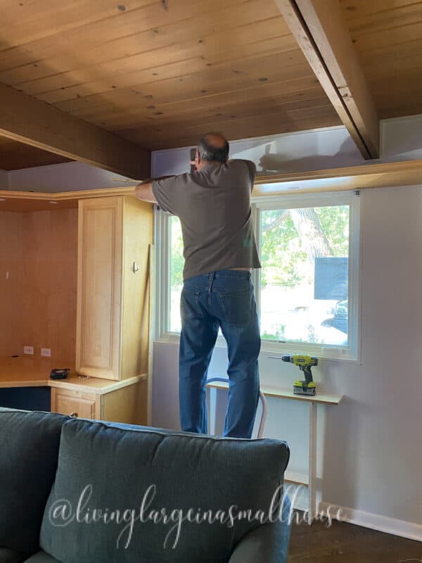 picture of handy taking down the top shelf for the one room challenge